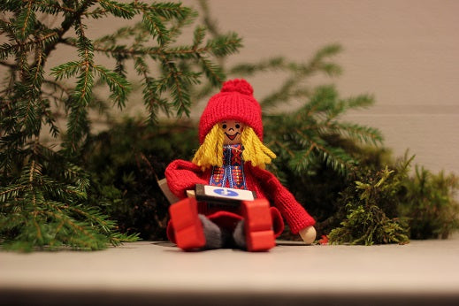 Sittande tomteflicka med surfplatta